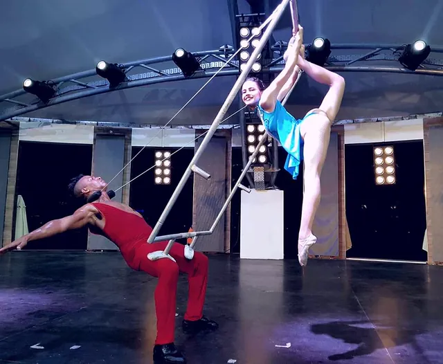 Maikel Mota como portor de un número aéreo, sosteniendo a una acróbata en el trapecio